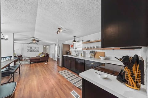 Open kitchen with quartz countertops and breakfast bar overlooking the living room.