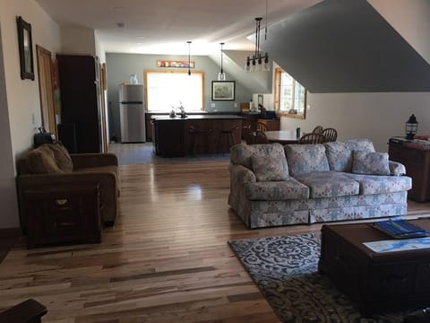 Open concept living space, dining room and kitchen. Hardwood flooring. 