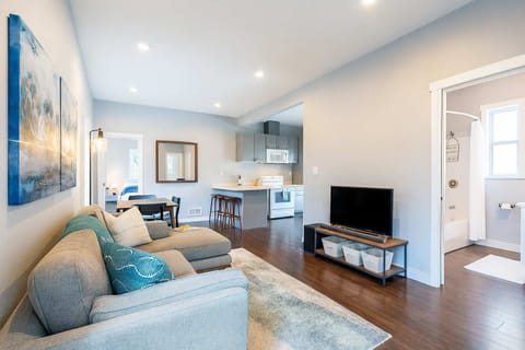 Spacious, inviting layout featuring a cozy sofa, smart TV, and seamless flow into the kitchen and bedroom.