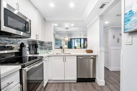 Sneak peeks of blue skies and palm trees through the living room sliders while prepping your meals.