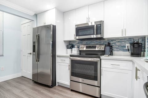 The kitchen features stainless appliances, stone countertops and copious storage space.