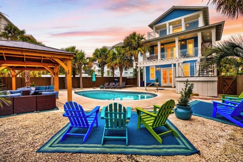 Private pool oasis with colorful lounge seating, a shaded pavilion, and a spacious coastal home made for group getaways.