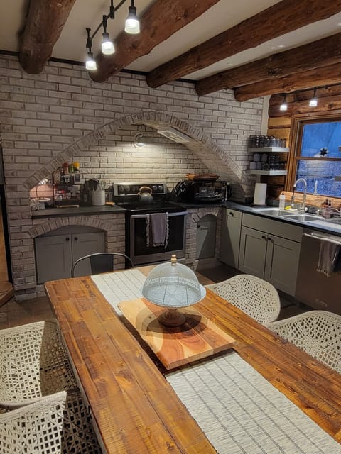 The brick floor and accent wall adds to the charm of this open kitchen