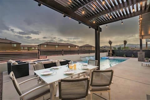 Poolside back patio dining area with pergola and views