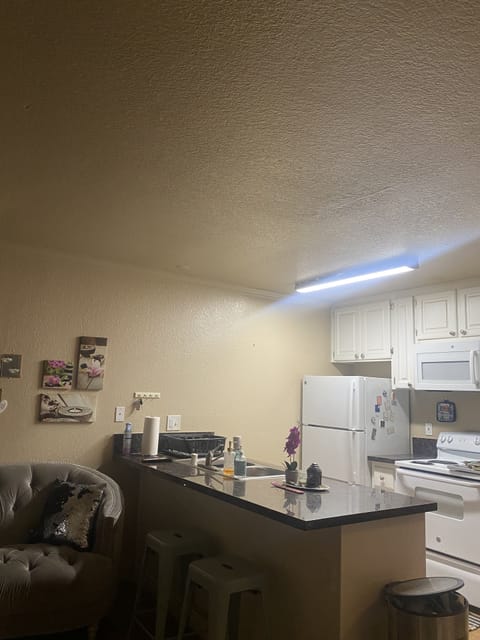 Open kitchen with bar stools for eating.