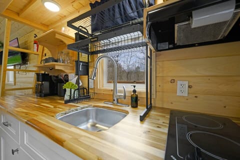 Bright, clean kitchenette with electric stove top and microwave overhead.