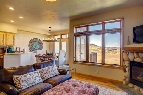 Cozy open floor plan with warm fireplace and expansive windows that frame stunning views, bringing the beauty of nature right into the living space.