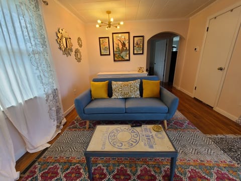 This cozy living room features eclectic furnishing and big sunny windows.