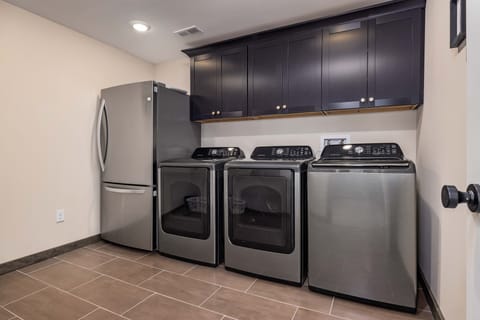 Laundry room with full size washer, 2 full size dryers and extra fridge/freezer