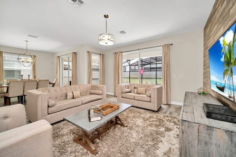 Enchanting living area of the home in Kissimmee Florida - Thoughtful mix of textures, from plush rugs to tasteful throw pillows - Harmonious color scheme with pops of accent colors for visual interest - Comfy sofas and smart TV for relaxation