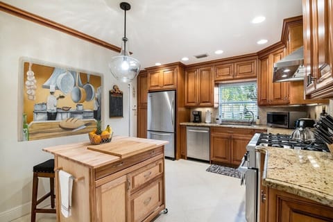 Our fully-equipped kitchen provides professional grade appliances, additional seating/food prep space at the kitchen island and a TV for your entertainment while you cook.