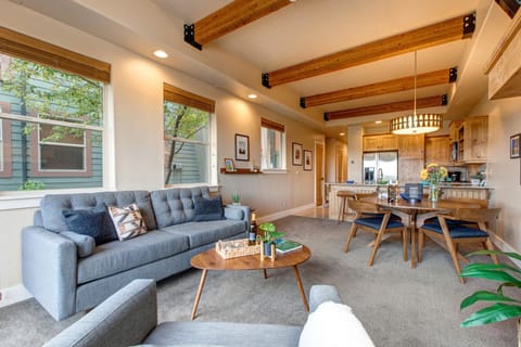 Living Room with plush couch, armchair, gas fireplace, 50" TV, and private hot tub patio access