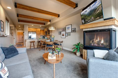 Living Room with plush couch, armchair, gas fireplace, 50" TV, and private hot tub patio access