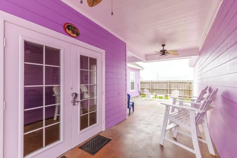 Your vibrant purple porch offers a cheerful welcome with cozy seating where you can unwind and enjoy refreshing outdoor moments.