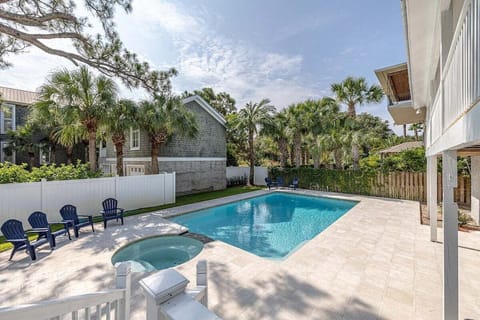 Backyard pool with hot tub and blue chairs