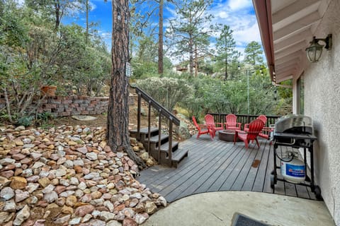 The patio is surrounded by pine trees creating a shaded and relaxing setting. 