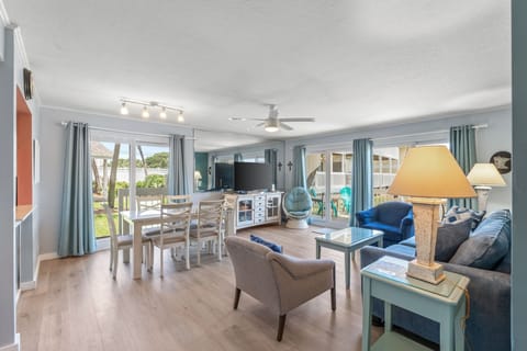 Relax in your bright, open living space with comfortable seating, dining table, and modern amenities, all bathed in natural light from expansive windows.