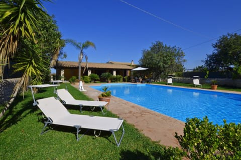 The wide pool, the well cared lawn and the Villa with the portico.