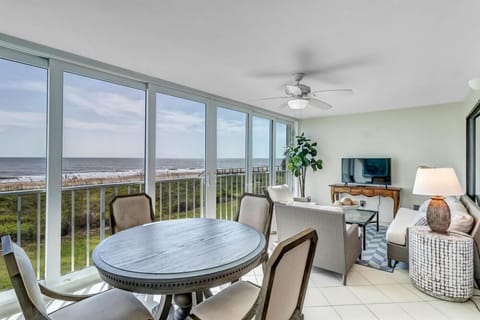 - Bright enclosed sunroom with wall to wall windows and direct ocean views
- Features round dining table, sofa, and smart TV for relaxing or entertaining
- Ideal for morning coffee, evening cocktails, or game nights with a view
