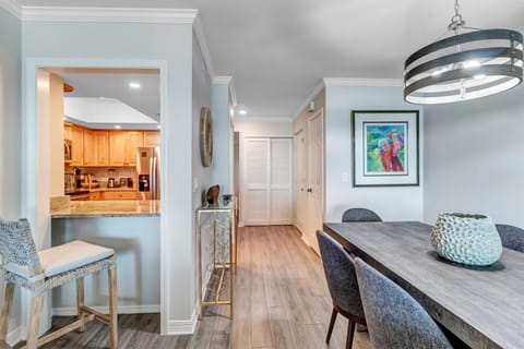 - Peek through kitchen opens to a stylish dining space and hallway beyond
- Bar seating makes a great spot for breakfast or evening wine
- Wood style flooring and curated artwork enhance the home's modern elegance