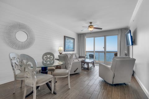 Living Room - Luxury and comfort meet in this beachfront living room with plush seating, a large flat-screen TV, and stunning ocean views through floor-to-ceiling windows.