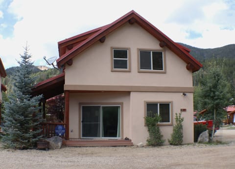 Nestled in a mountain valley with wooded hillsides, this property features distinctive red roof detailing and easy access to nature.