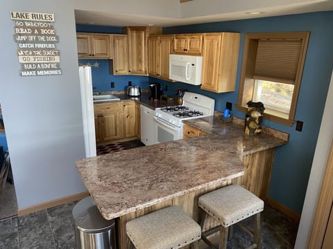 The full kitchen boasts an oven, gas range, fridge, microwave, and dishwasher.