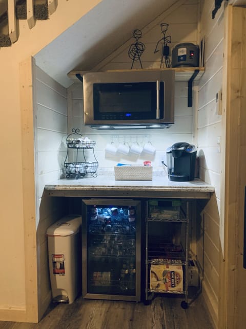 kitchenette area in lower level with coffee maker , microwave and small fridge