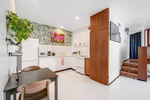 The kitchen is stocked with a full set of appliances including basic kitchen utensils. 