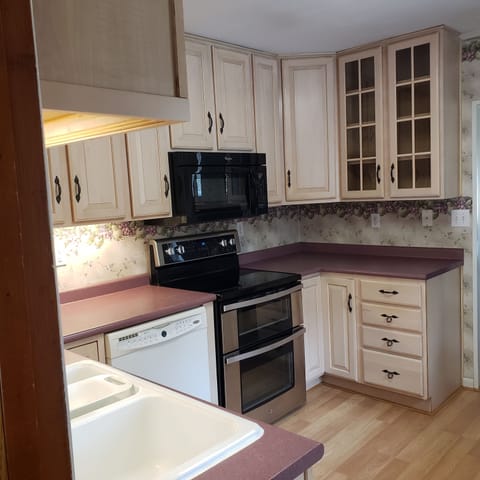 Kitchen stocked with pots/pans, plates, glasses, and utensils. Coffee maker