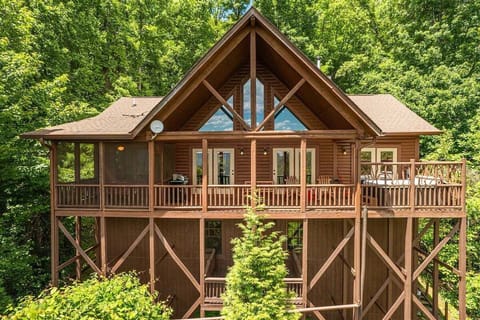 View of the cabin's large back deck surrounded by trees. Perfect for morning coffee in Bryson City, NC with peace, privacy, and wooded scenery.