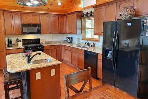 A spacious kitchen with granite countertops, modern appliances, and a center island makes meal prep easy at Smoky Mountain High.