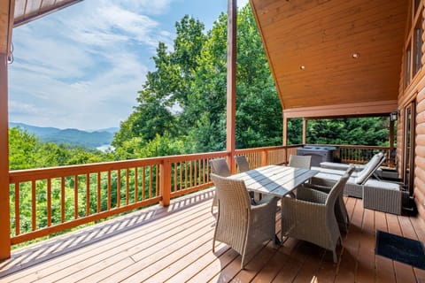 Relax on the spacious covered deck with cushioned outdoor seating overlooking the Smoky Mountains near Bryson City. The elevated porch offers a comfortable place to enjoy the surrounding scenery.