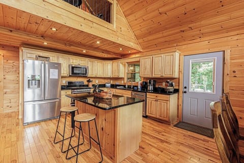 Modern kitchen with stainless steel appliances, center island, and barstool seating for family meals.