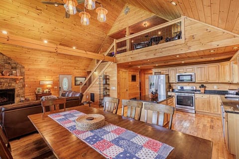 Spacious dining room with large wooden table and open access to the modern kitchen.