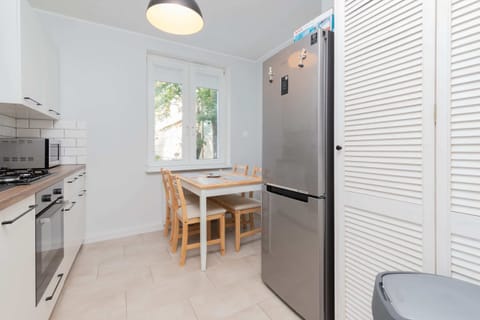A fully equipped kitchen with white cabinets, a large stove, and a window letting in daylight.
