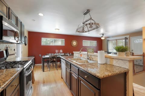 - Spacious kitchen with rich granite countertops, stainless appliances, and island seating
- Bold red accent wall adds character while multiple windows bring in daylight
- Ideal setup for cooking, dining, and gathering in one seamless space