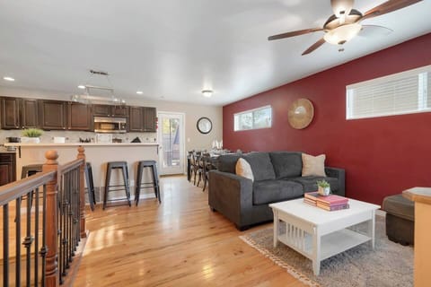 - Open layout connects kitchen, dining, and living areas for seamless flow
- Bold red accent wall adds warmth to this modern and inviting space
- From coffee at the bar to group dinners, this area is built for connection