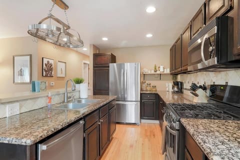 - Sleek kitchen with dark cabinetry, granite countertops, and stainless appliances
- Plenty of prep space and stylish lighting make this a dream for cooking enthusiasts
- Everything you need is at your fingertips in this polished, modern space

