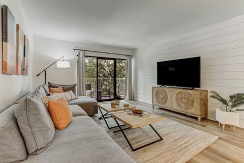 Spacious Living Area with a Flat Screen Smart TV, Shiplapped Walls, and a Gorgeous View of the Pool and Pond