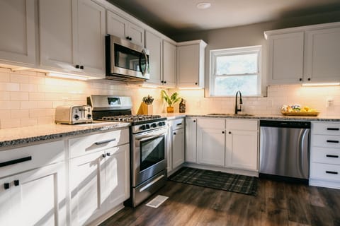 Fully equipped kitchen with complimentary snacks, coffee, and water bottles.