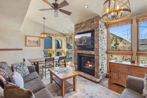 Floor-to-ceiling windows fill the space with natural light, making the living/kitchen and dining area feel open and airy.
