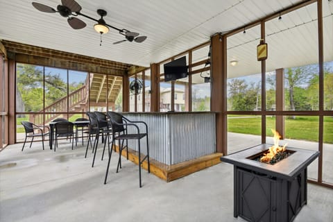 Outdoor bar area featuring a firepirt and a TV.  