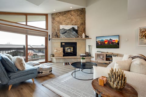 Your mountain retreat living room features a cozy stone fireplace and comfortable seating where you can unwind after alpine adventures.