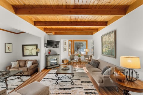 Unwind in this inviting living space with exposed wood beams, cozy fireplace, and comfortable seating where you'll create lasting memories.
