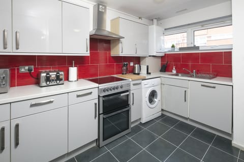 Fitted kitchen with dish washer dryer and clothes dryer. 