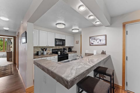 Full kitchen with breakfast bar seating 2.