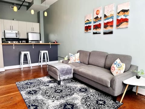Cozy living room with sofa, rug, and open kitchen