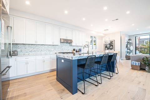 Barstools line the kitchen island with comfortable seating for three
                