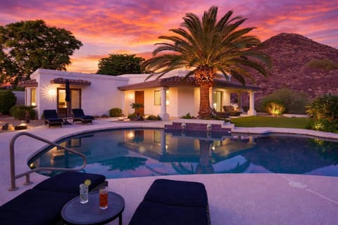 Resort style backyard with private pool, hot tub, lounge chairs, outdoor dining, corn hole, built in grill and fire pit!